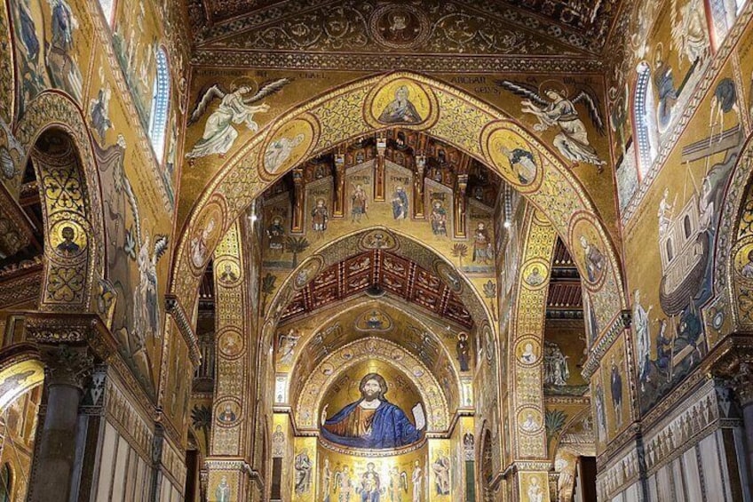 An ornate interior with golden mosaics, arches, and a central figure. 4