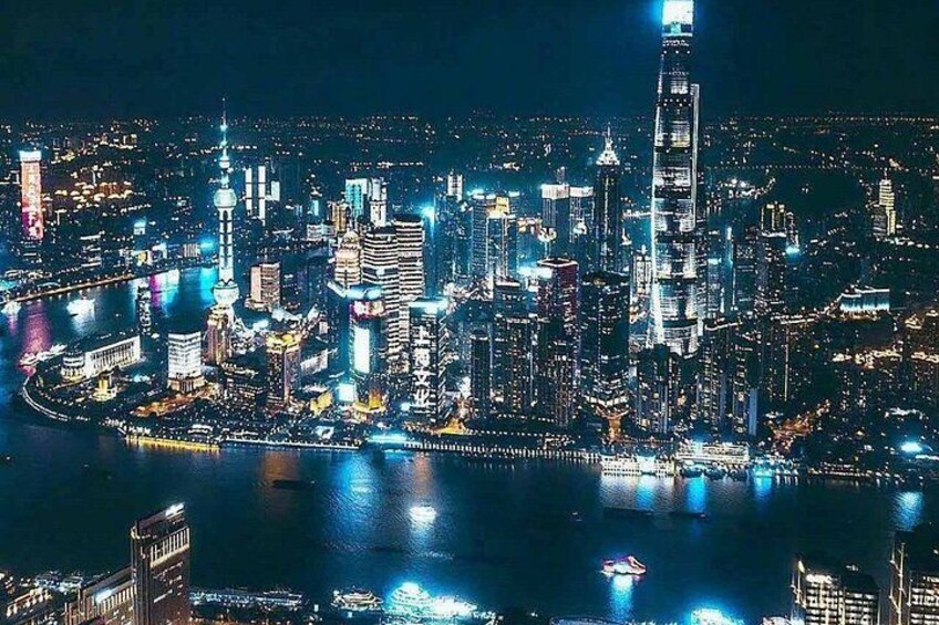 A cityscape at night with illuminated buildings and a river. 5