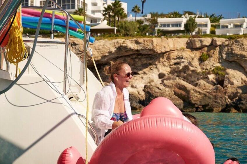 A person on a boat with a rocky coastline and buildings in the background. 5