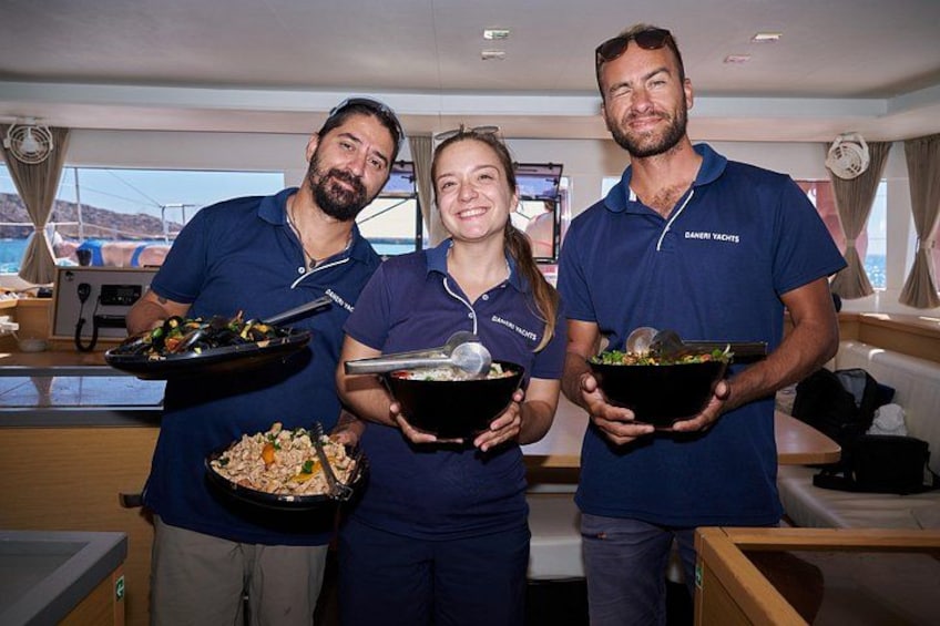 Three people holding bowls of food on a boat. 4