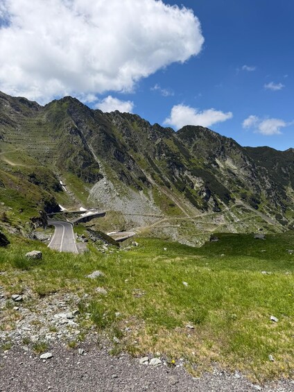 A winding mountain road with rocky terrain and lush greenery. 5