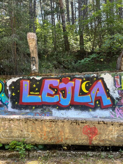 A graffiti-covered concrete wall with the word 'LEJLA' and the name 'WILLIAM' in colorful letters. 3