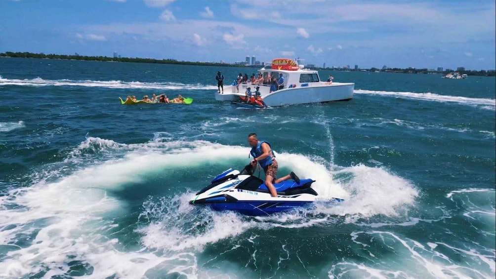A person jet skiing on a body of water with a boat in the background. 4