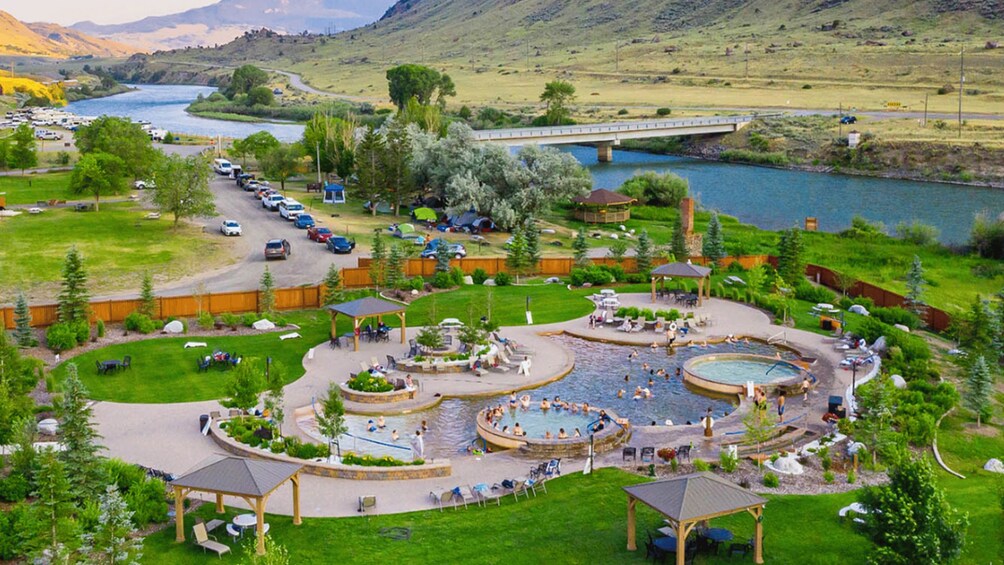 A recreational area with a swimming pool, a bridge, and a river. 2