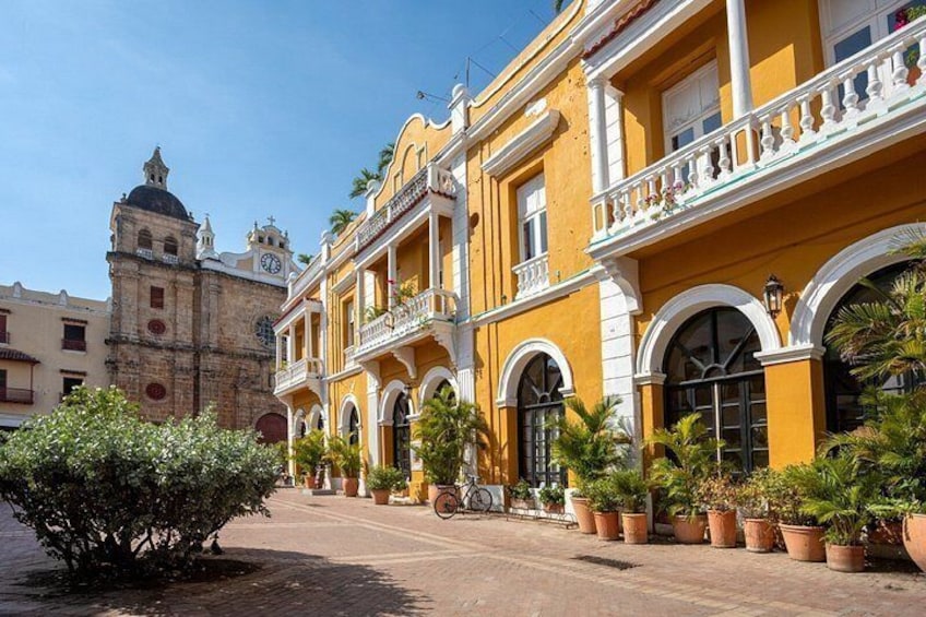 A historic building with yellow and white facades, arched windows, and a bell tower. 3