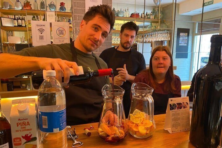 Eine Person gießt ein Getränk in ein Glas an der Bar. 1