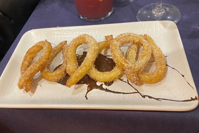 Ein Teller mit Churros, Schokoladensauce und Zucker. 4