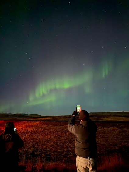 Eine Person fotografiert das Nordlicht. 4