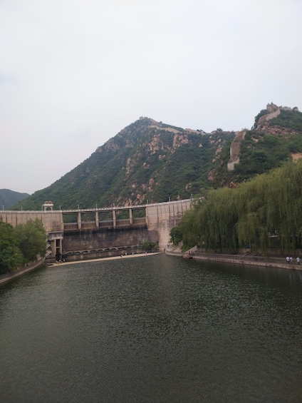 A dam with a bridge, a river, and a hill with a fortification. 3