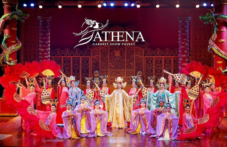 A group of performers in traditional Chinese costumes on a stage with a red and gold color scheme, holding fans and wearing elaborate headpieces. 4