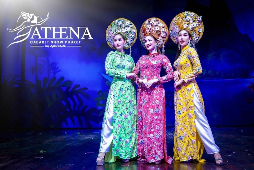 A stage with three performers in traditional costumes and elaborate headdresses. 3