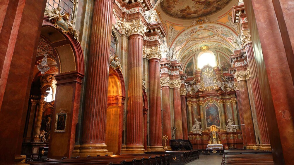 An ornate church interior with tall columns, detailed frescoes, and a central altar. 2