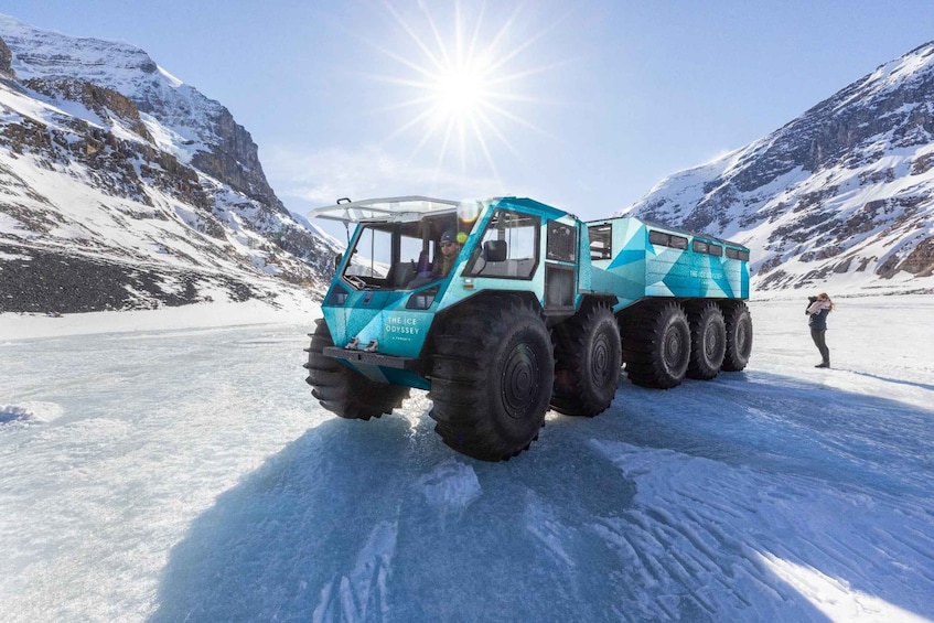 A large blue truck on a snowy mountain road. 1