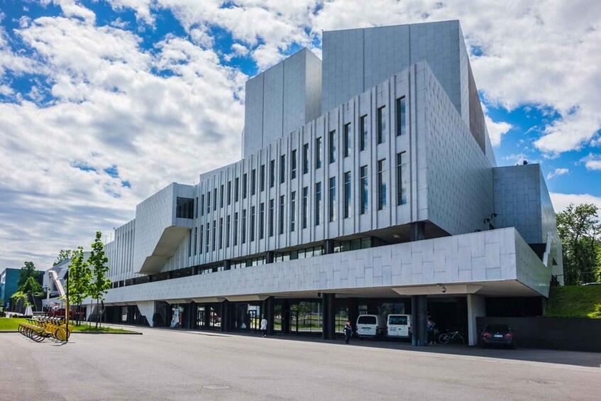 A modern architectural building with a unique geometric design, featuring a large overhang and multiple windows. 2