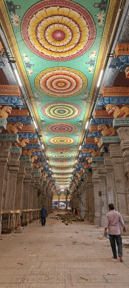 A temple interior with intricate ceiling artwork and lion statues. 4