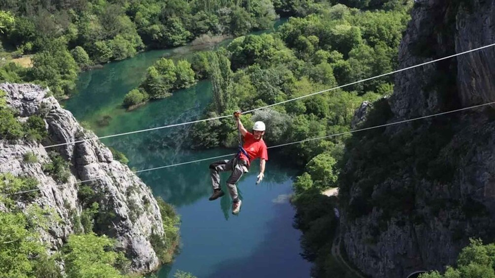A person bungee jumping from a cliff over a river. 3