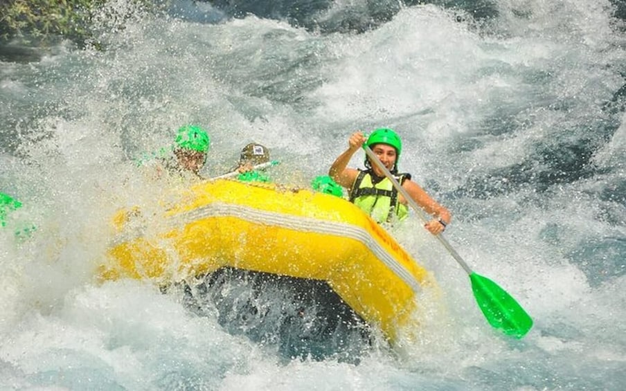 Two people in a yellow raft navigating through white water rapids. 5
