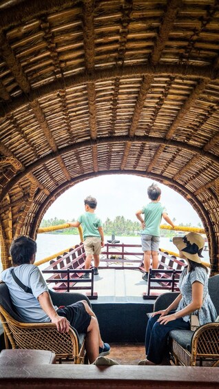 A covered boat with passengers looking out at the water. 5