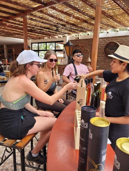 A group of people at a bar with a rustic interior, wooden beams, and a brick wall. 3