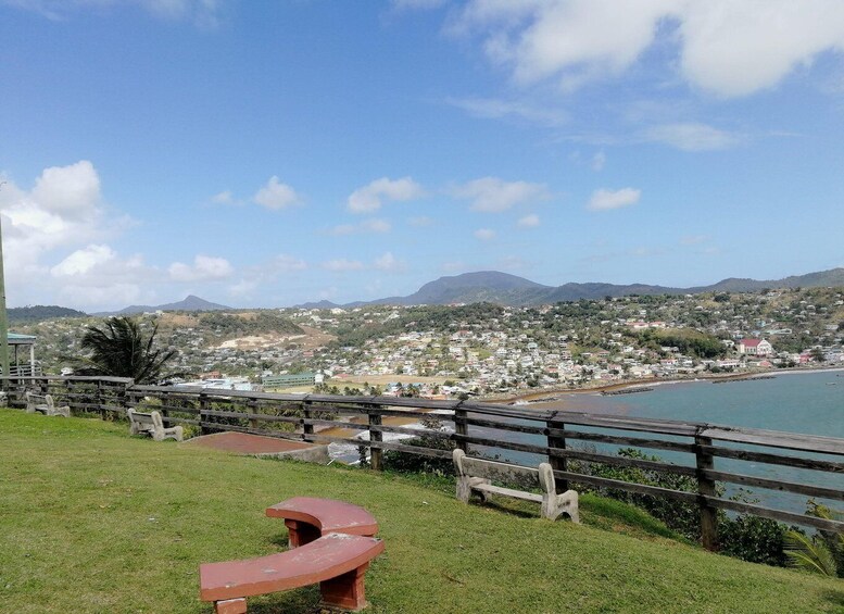 A coastal town with a beach, picnic tables, and a mountain in the background. 5