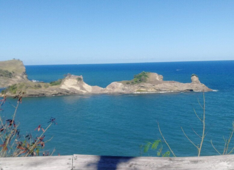 A coastal landscape with rocky cliffs and a clear blue sea. 1