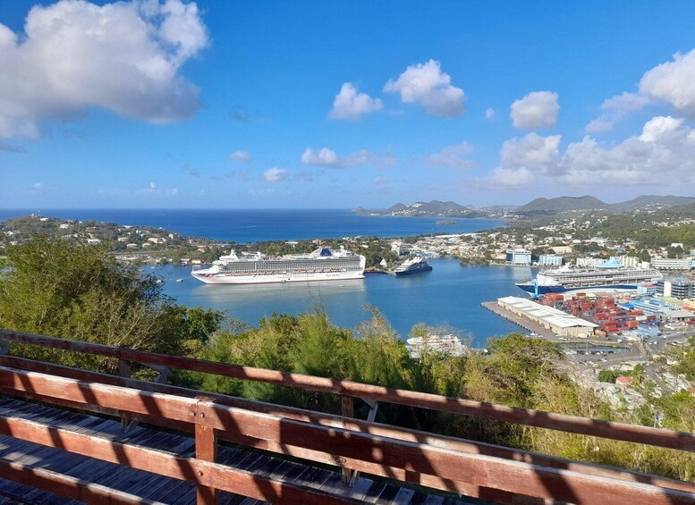 A cruise ship docked at a port with a cityscape and mountains in the background. 3