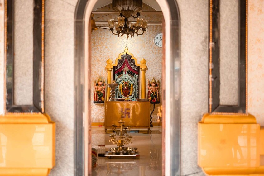 An ornate shrine with a golden altar, a clock, and a chandelier. 2