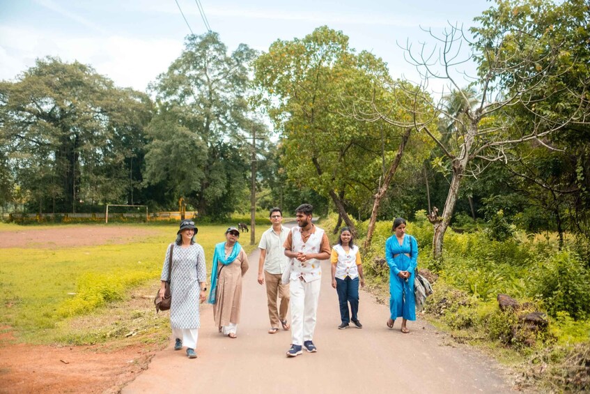 A group of people walking on a rural path surrounded by greenery. 3