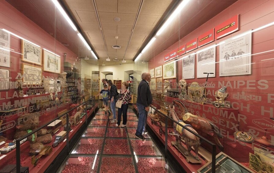 A museum corridor with glass display cases containing historical artifacts and documents. 3