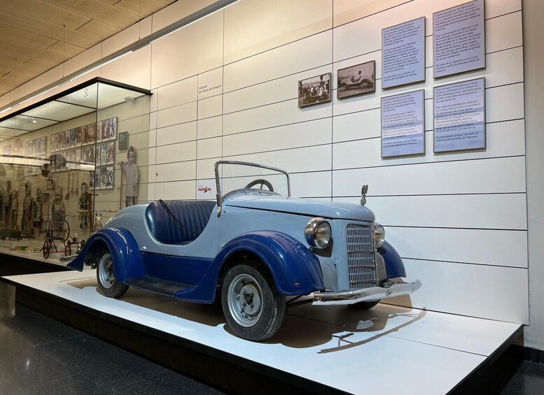 A vintage blue car on display in a museum. 5