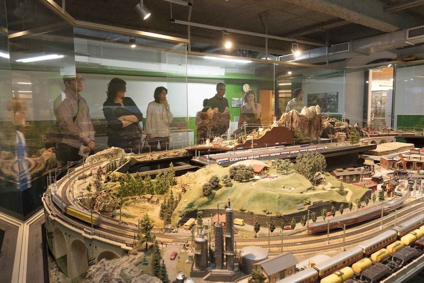 A detailed model train layout with multiple tracks, bridges, and buildings. 2
