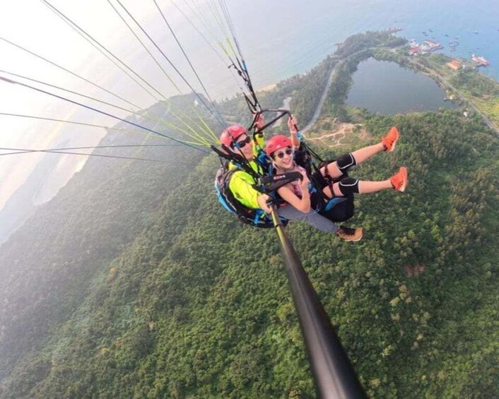 A person skydiving with a parachute, surrounded by lush green mountains and a lake. 4