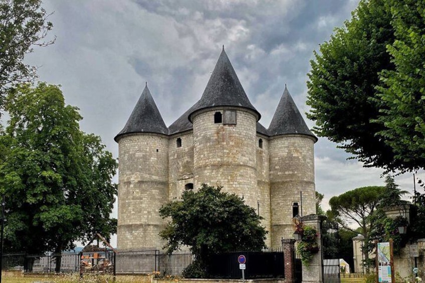 A historic stone castle with three towers and a surrounding fence. 2