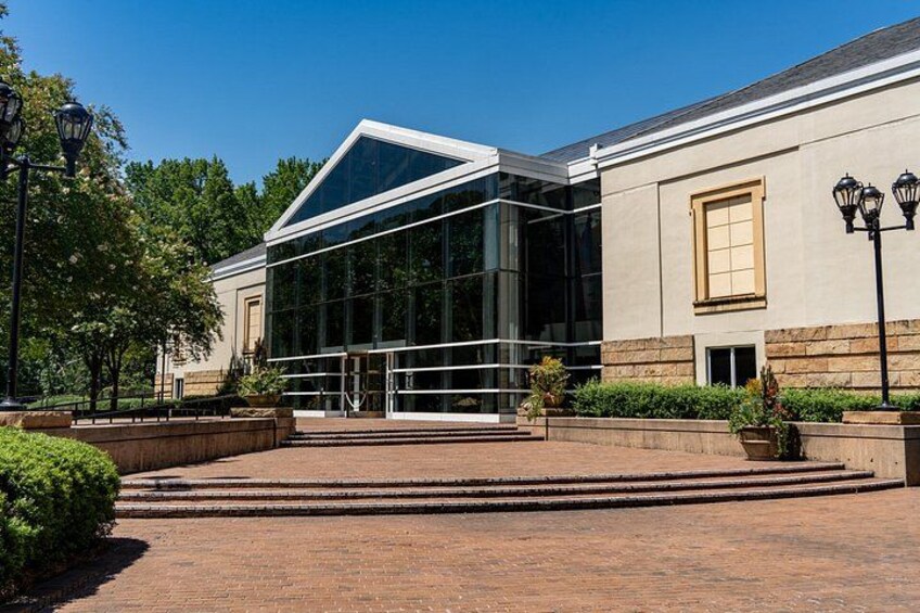 A modern building with large glass windows and a brick pathway leading to it. 4