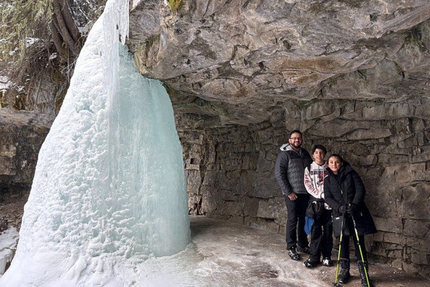 Une importante formation de glace dans une grotte rocheuse, avec des personnes se tenant à proximité. 5