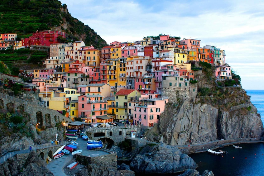 A colorful coastal village with buildings stacked on cliffs overlooking the sea. 1
