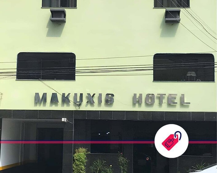 The exterior of Makuxis Hotel with a signboard, windows, and a logo. 2