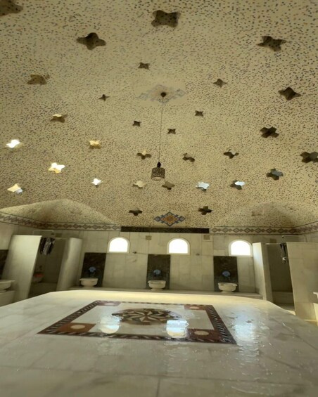 A large room with a patterned floor, a hanging light fixture, and star-shaped ceiling decorations. 4