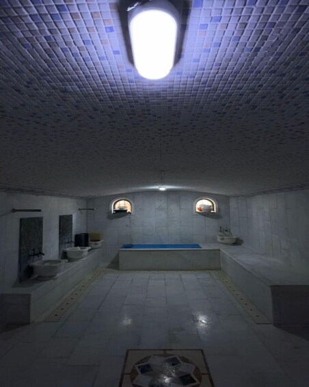 A tiled bathroom with a bathtub, two sinks, and a toilet. 5