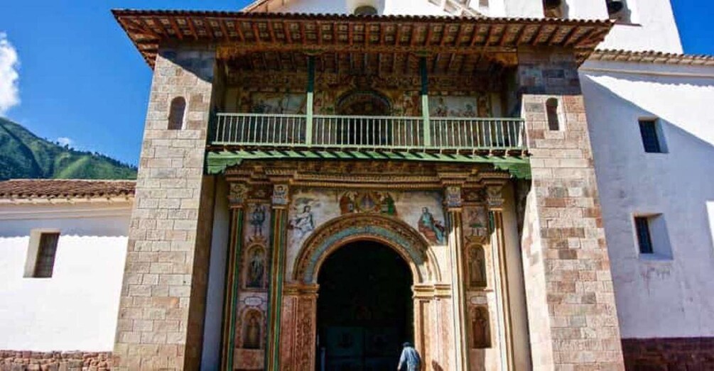 A historic building with a detailed facade, an arched entrance, and a balcony. 2