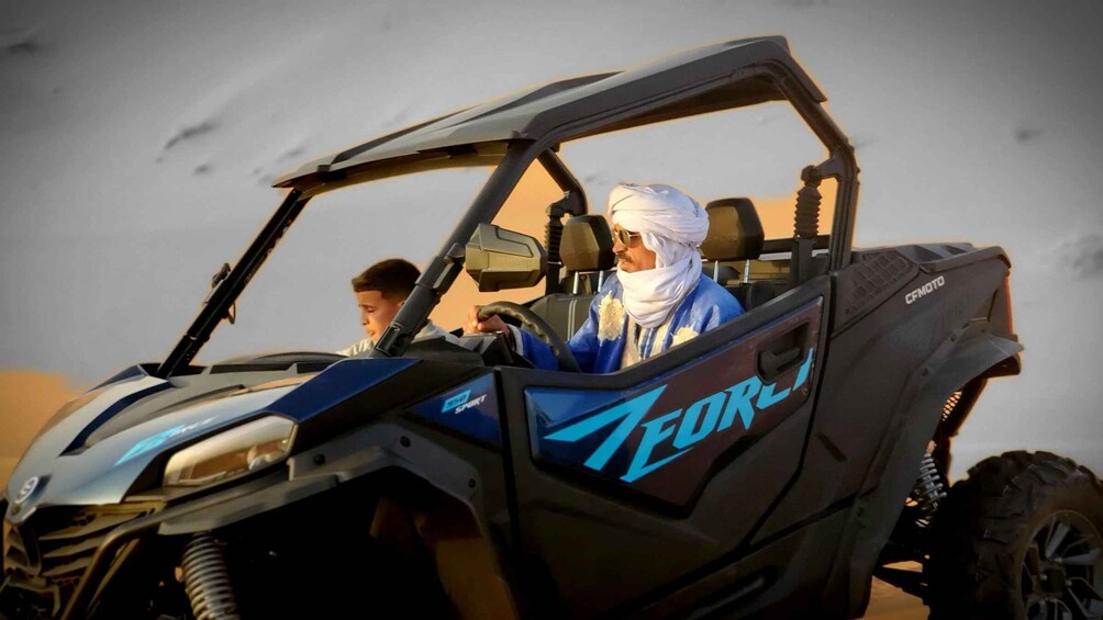 A blue and black off-road vehicle with 'Teorex' branding, parked in a desert environment. 3
