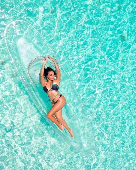 A person floating on a clear water surface in a tropical setting. 3