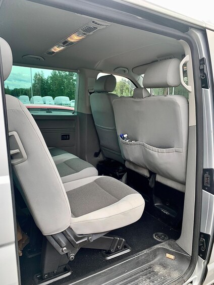 A vehicle interior with grey seats, a central console, and a rear storage compartment. 2