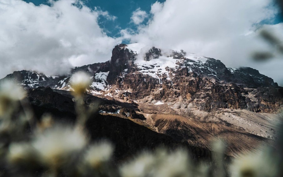 A mountain with snow-capped peaks and a rocky foreground. 1