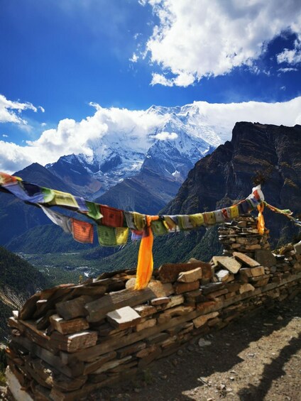 A mountain landscape with a stone wall and prayer flags. 3