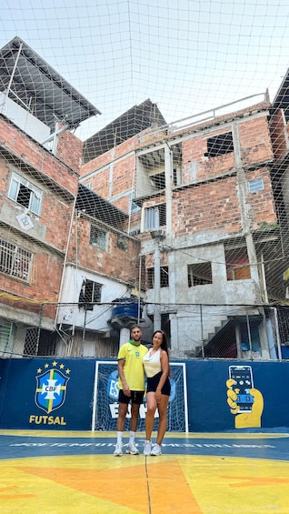 A soccer field with a blue and yellow goalpost, a fence, and a partially constructed building in the background. 5
