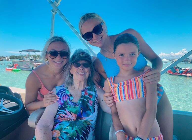 A family on a boat with a clear blue sky and calm water. 2