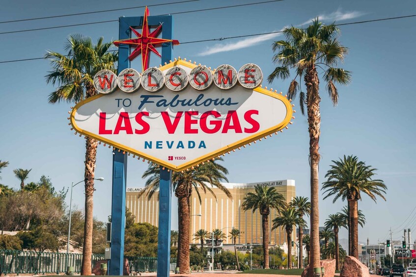 «Tervetuloa upeaan Las Vegasin kaupunkiin, Nevada» -kyltti, jossa on palmuja ja taustalla näkyy rakennus. 1