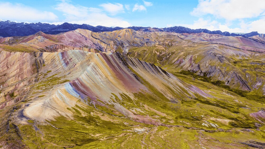 A colorful mountain range with distinct layers of rock and sparse vegetation. 3