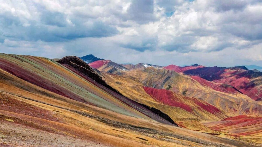 A colorful mountain range with a cloudy sky. 1